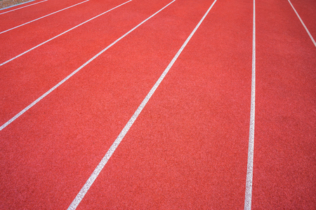 White lines of stadium and texture of running racetrack red rubber racetracks in outdoor stadium are 8 track and green grass field,empty athletics stadium with track.の写真素材