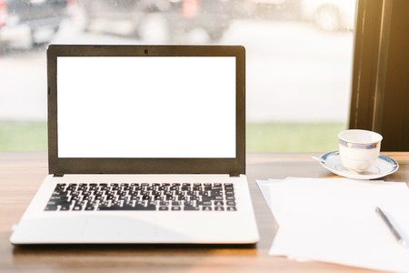 Mockup image of laptop with blank white screen,smart phone and document on wooden table of In the coffee shop.の写真素材