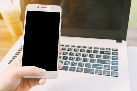 Close-up of business female working with smartphone with blank black screen make a note document and...