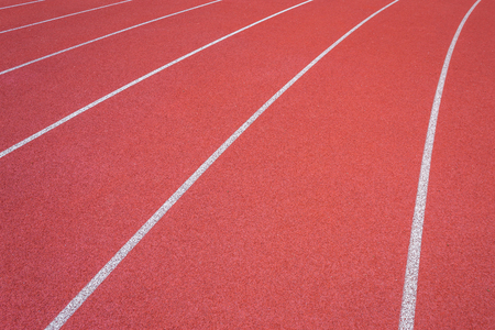 White lines of stadium and texture of running racetrack red rubber racetracks in outdoor stadium are 8 track and green grass field,empty athletics stadium with track.の写真素材