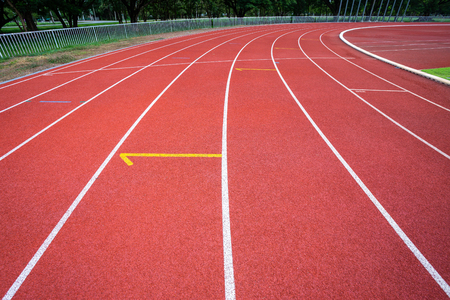White lines of stadium and texture of running racetrack red rubber racetracks in outdoor stadium are 8 track and green grass field,empty athletics stadium with track.の写真素材