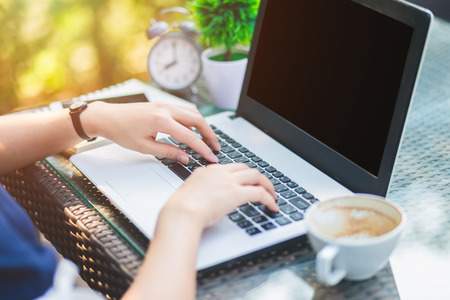 Close-up of Business female working with laptop, coffee, clock, smart phone, and notebook on office outdoorの写真素材