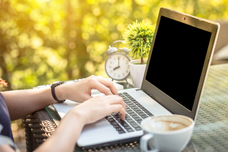 Close-up of Business female working with laptop, coffee, clock, smart phone, and notebook on office outdoorの写真素材