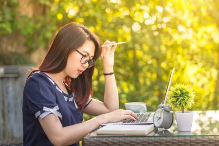 Asian business female working with laptop on office outdoor,Think about the jobの写真素材