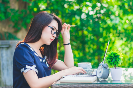 Asian business female working with laptop on office outdoor,Think about the jobの写真素材