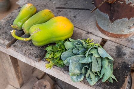 Old thai charcoal stove with Green leafy vegetables and papaya put on a wooden table are Thai traditional kitchen style.の写真素材