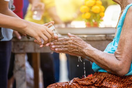 pouring water on the hands of revered elders and ask for blessing happy for the songkran festival in Thailand, Traditional Thailand New Year.の写真素材