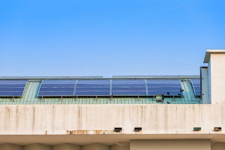Photovoltaic solar panels on building roof on blue sky background, energy system electricity generation,Alternative energy concept.の写真素材