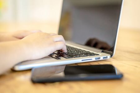 Close-up of business female working with laptop and smartphone in coffee shop like the background