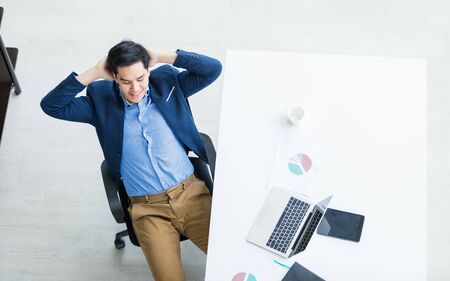 Happy of successful asian young businessman on laptop computer, tablet with blank touch screen isolated and Pen on notebook on White wooden table background in office top viewの写真素材