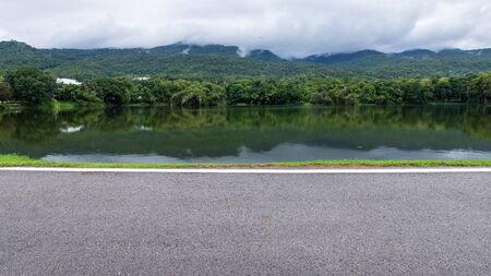 Asphalt black grey road landscape lake views at Ang Kaew Chiang Mai University in nature forest Mountain views spring blue sky background with white cloud.の写真素材