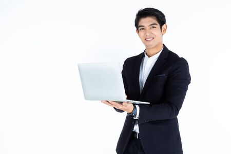 fashion portrait of handsome young Asian businessman working with laptop computer isolated on white grey blank copy space studio background,Business success conceptの写真素材