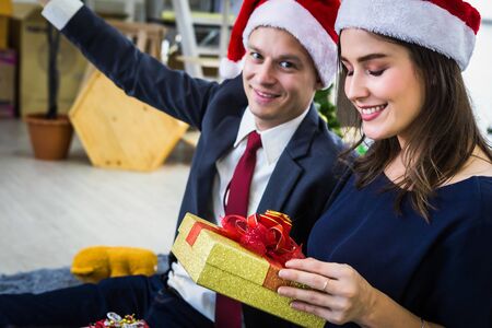Happy new year 2020 concept,Happy couple holding exchanging gifts and Give a present in Christmas and New Year's Eve party Christmas tree background After finishing business workの写真素材