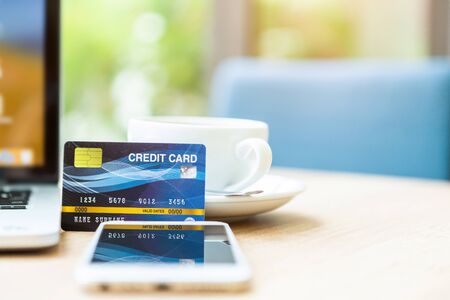 Credit card of laptop computer,smartphone and coffee cup on wooden table of In the coffee shop background,Online banking Conceptの写真素材