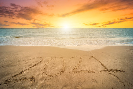 Happy New Year 2021 text on beautiful the sea beach with wave early morning sunrise over the horizon background.During Christmas and New Year.の写真素材