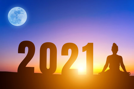 Happy New Year Numbers 2021, Silhouette woman practicing yoga early morning sunrise over the horizon...