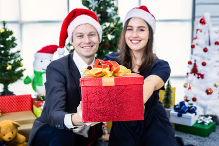 Happy new year 2020 concept,Happy couple holding exchanging gifts and Give a present in Christmas and New Year's Eve party Christmas tree background After finishing business workの写真素材