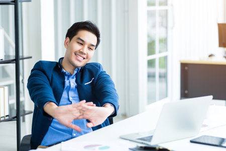 Happy of successful asian young businessman on laptop computer, tablet with blank touch screen isolated and Pen on notebook on White wooden table background in officeの写真素材