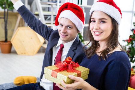 Happy new year 2020 concept,Happy couple holding exchanging gifts and Give a present in Christmas and New Year's Eve party Christmas tree background After finishing business workの写真素材