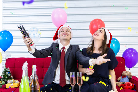 Happy new year 2020 concept,Happy couple lighting paper fireworks With champagne and cookies on the table in Christmas and New Year's Eve party After finishing business work.の写真素材