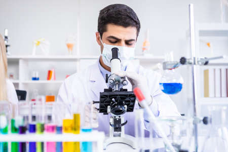 Male scientist working looking at Microscope with sample test tube in a chemistry lab scientist researcher are doing investigations in Laboratory analysis backgroundの写真素材