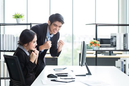 Happy of businesswoman and businessman partners discussing positive adult business working together with computer on wooden table and ideas at meeting in office background.の写真素材