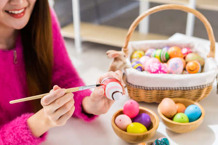 Easter holiday concept,Close up of Happy Asian Young woman hand painted eggs for Easter with...
