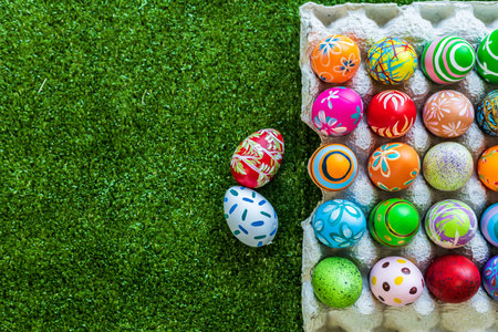 Easter holiday concept,Colorful Easter eggs in egg box,basket Easter eggs in green grass background with space.の写真素材