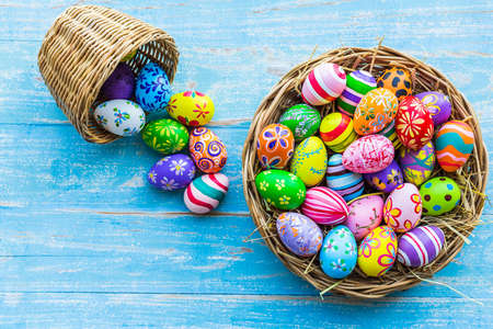 Easter holiday concept,Colorful Easter eggs in basket on blue pastel color rustic wood background with space.の写真素材