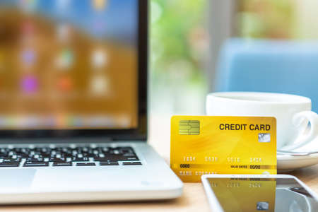 Credit card of laptop computer,smartphone and coffee cup on wooden table of In the coffee shop background,Online banking Conceptの写真素材
