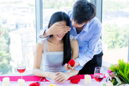 Valentine's day and asian Young happy sweet couple concept,asian a man with engagement ring making proposal of marriage to woman after lunch In a restaurant background, bride and groom wedding plansの写真素材