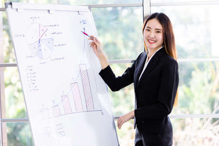 Businesswoman boss partners presenting new project ideas and the increase in received bracelets background in office,female coach presenting successful business planの写真素材