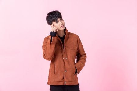 Asian a man handsome young thinking on something in love isolated on pink blank copy space studio background.の写真素材