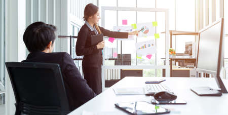 businessman and businesswoman boss Two partners presenting new project ideas and the increase in received bracelets background in office,female coach presenting successful business planの写真素材