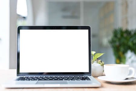 Mockup of laptop computer with empty screen with coffee cup on table of the coffee shop background,White screenの写真素材