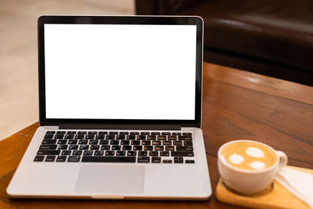Mockup of laptop computer with empty screen with coffee cup on table of the coffee shop...
