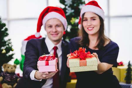 Happy new year 2021 concept,Happy couple holding exchanging gifts and Give a present in Christmas and New Year's Eve party Christmas tree background After finishing business workの写真素材