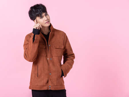 Asian a man handsome young thinking on something in love isolated on pink blank copy space studio...
