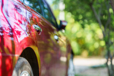 Red auto opening a car door window or automobile motor car of shiny convertible luxury outside background,transportation trip conceptの写真素材