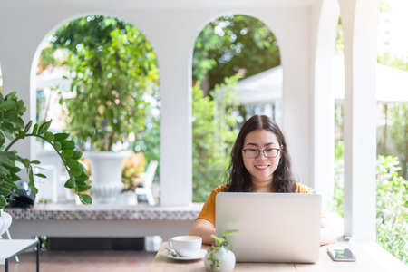 Happy of asian freelance people business female casual working with laptop computer with coffee cup and smartphone in coffee shop like the background,communication conceptの写真素材