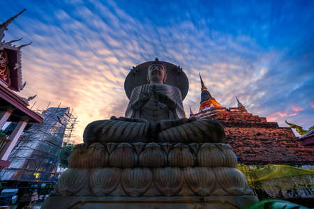 PHITSANULOK, THAILAND - October 10,2020:Buddha statue and Phra Chedi Luang in Temple (Thai language:Wat Ratchaburana) is a Buddhist temple It is a major tourist attraction in Phitsanulok, Thailand.の素材 [FY310178947151]