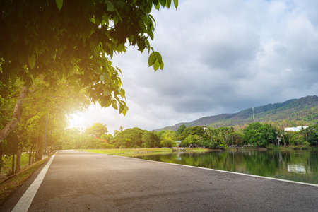 Asphalt black grey road landscape lake views at Ang Kaew Chiang Mai University in nature forest Mountain views spring blue sky background with white cloud.の写真素材