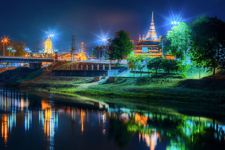 light on the Nan River on the Naresuan Bridge and Chedi of Wat Ratchaburana and Prang Wat Phra Si Rattana Mahathat also colloquially at the Nan River and the park at night in Phitsanulok, Thailand.の写真素材