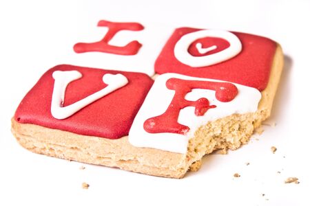 A square cookie, with a bite taken,  frosted with the word の写真素材