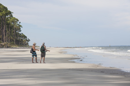 Two teenage male tourists strolling on a beach in South Carolinaの写真素材