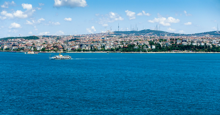View from the European side of Istanbul across the Bosphorus to the Asian side of Istanbul. A ship is crossing the Bosphorus and the Maidens Tower is on the left.の写真素材