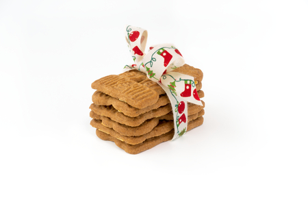 Stacked Spiced Biscuits with Almonds ( Spekulatius ) decorated with festive Christmas Bow on white background.の写真素材