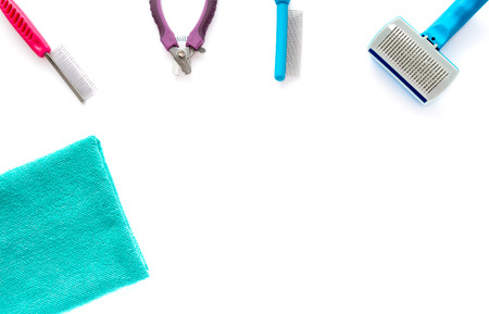 Cat and dog grooming tools: fine toothed comb, wide toothed comb, slicker brush, small nail clipper and a microfiber towel isolated on white background.の写真素材