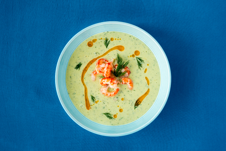 Chilled Cucumber and Crayfish Soup with dill on blue background with copy space.の写真素材