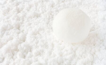Closeup of a large snowball on white snow background.の写真素材